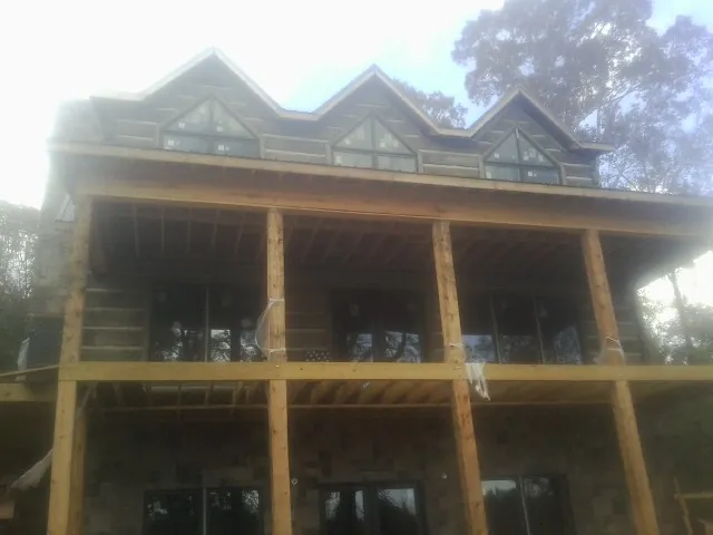 Dormers and porch framing on a large log home under construction — Roof Coating work by our crew in Wampum