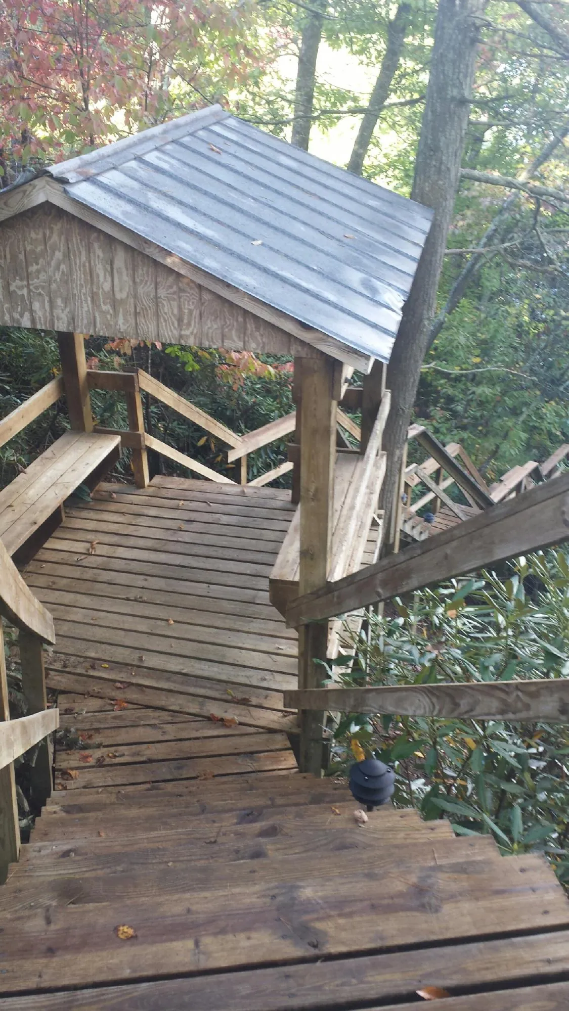 Metal roofed shelter over wooden steps on a wooded walkway — Skylight Repair & Installation work by our crew in Wampum