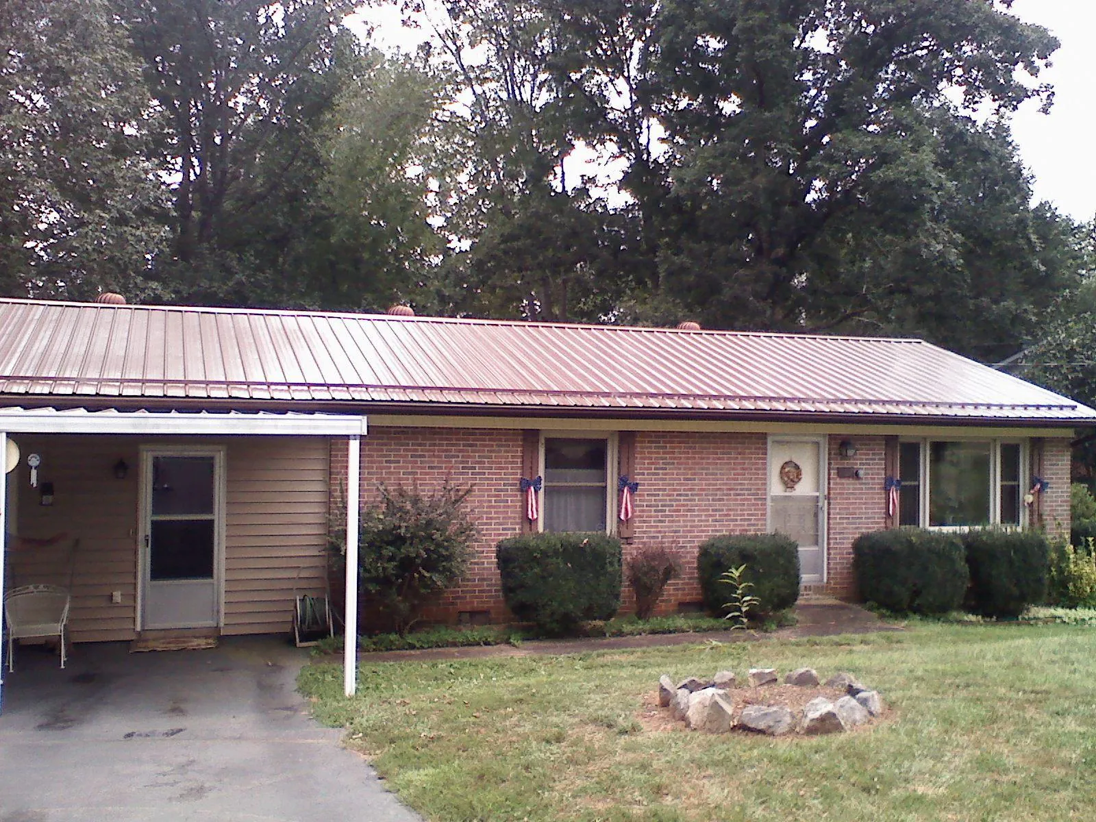 Bronze metal roof and carport on a brick ranch home — Roof Repair work by our crew in Wampum